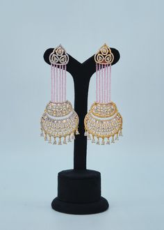 These premium-quality Nayab Statement CZ Chandelier Long Earrings boast eye-catching emerald crystal beads and a baguette diamond centerpiece, perfect for adding a subtle pop of color and sparkle to any ensemble. Crafted with cubic zirconia dangles, these earrings are sure to elevate your look. Length: Approx. 4" Weight of each earring: 20 gms Push-Back closure Finish: Gold Polish High-quality brass as the base metal. Availability: In-Stock. *Color may vary slightly due to light condition & phot Luxury Traditional Festive Chandelier Earrings, Luxury Traditional Chandelier Earrings For Festive Season, Luxury Festive Fusion Chandelier Earrings, Luxury Festive Danglers, Luxury Festive Chandelier Earrings For Celebration, Luxury Chandelier Earrings For Diwali Festive, Luxury Red Traditional Chandelier Earrings, Luxury Festive Chandelier Earrings For Diwali, Chandelier Long