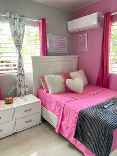 a bedroom with pink walls and white furniture