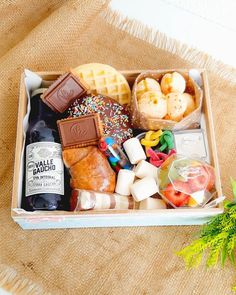 a box filled with different types of food on top of a table next to a potted plant