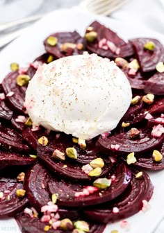 beet salad with poached egg and pistachio seeds on a white plate