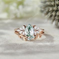 a green and white ring sitting on top of a sandy ground next to a pine tree