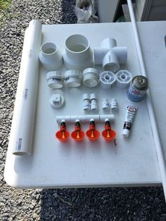 there are many different types of pipes and fittings laid out on a white table