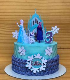 a frozen princess birthday cake with the number 3 on top and two figures in front