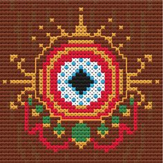 a cross stitch pattern with an eye in the center and flowers on the bottom side