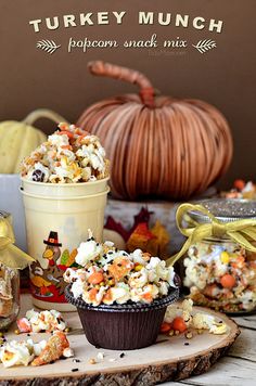 popcorn snack mix in a cup on a wooden board with pumpkins and other decorations