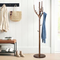 a coat rack with shoes on it next to a bench