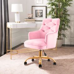 a pink office chair sitting in front of a desk with a potted plant on it