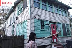 a woman standing in front of a house that has been gutted with wood and paint