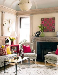 a living room filled with furniture and a fire place under a painting on the wall