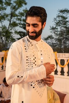 a man with a beard wearing a white outfit