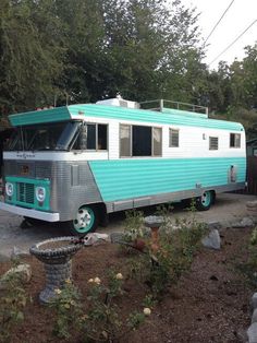 a blue and silver trailer parked next to trees