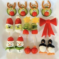 an assortment of food items displayed on a white plate with red ribbon and reindeer hats