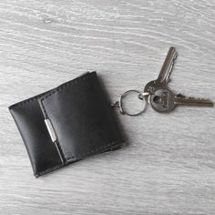 a black leather wallet with two keys in it