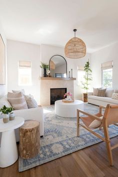 a living room filled with furniture and a fire place next to a white couch on top of a wooden floor