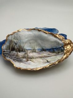 a blue and gold platter with an image of a snowy landscape in the center