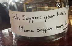 there is a jar with some sort of substance in it on the table next to a sign that says, we support your heart