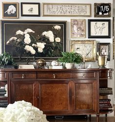 a living room filled with lots of pictures and flowers on top of a wooden table