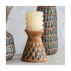 three vases with candles in them sitting on a table next to each other,