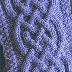 a close up of a knitted object on a table cloth with knots in the middle