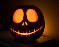 a carved pumpkin with glowing eyes and teeth