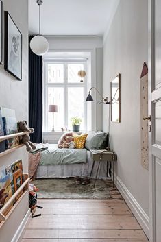 a bedroom with a bed, bookshelf and pictures on the wall above it