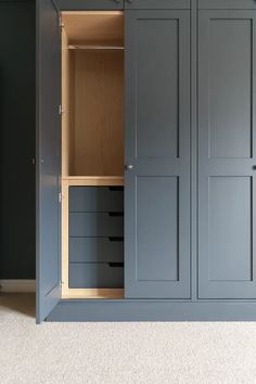 an empty closet is shown with drawers and cupboards in the corner, along with carpeted flooring