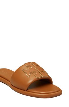 A sleek leather slide accented by Tory's signature double-T logo is ready to upgrade your warm-weather style. Leather upper and lining/rubber sole Imported Tan Leather Footbed Slip-on Sandals, Designer Leather Slip-on Slides, Luxury Leather Slides With Leather Footbed, Classic Tan Leather Sandals, Tan Leather Open Toe Slides, Casual Calf Leather Slides With Removable Insole, Designer Slides With Leather Footbed And Round Toe, Leather Sandals With Round Toe And Leather Trim, Designer Slides With Round Toe And Leather Footbed