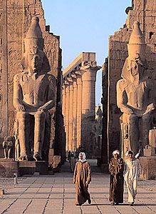 two large statues sitting next to each other in front of some tall building's