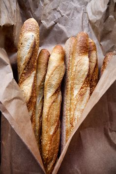 four loaves of bread in a brown paper bag