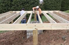 two men are working on a wooden structure