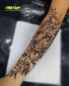 a woman's arm with a cheetah and flowers tattoo design on it