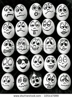 black and white photo of many different faces drawn on eggs in the shape of balls