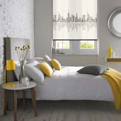 a bedroom with white walls and yellow shades on the windows, along with a bed