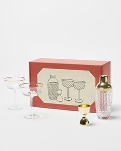 three wine glasses in front of a red box with a drawing on the side and an empty glass next to it