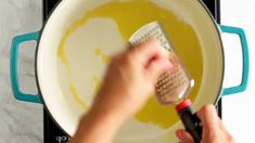 a person using a grater to stir food in a pan