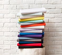 a stack of folded sheets in front of a brick wall