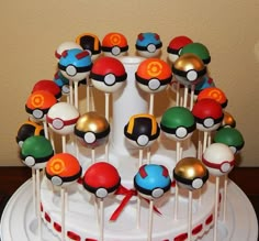 a white cake topped with lots of pokeball lollipops