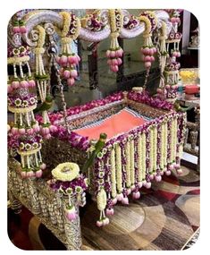 an elaborately decorated bed with flowers and beads on the headboard is shown in front of a mirror