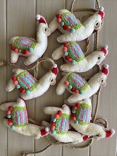 some white stuffed animals are hanging on a string and decorated with bead trimmings