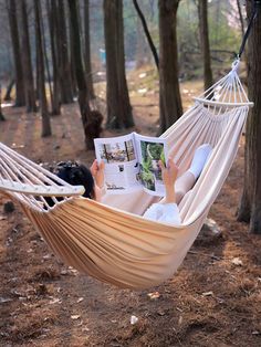 a person laying in a hammock reading a book