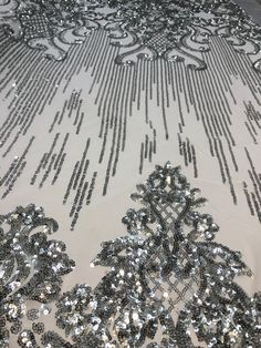 silver sequins on white sheer fabric with black and white design in the center