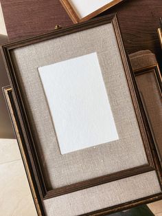 an old photo frame sitting on top of a table next to a pen and paper