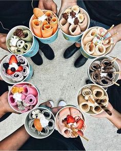 several people are holding bowls with food in them