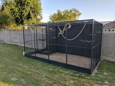 a large black cage in the middle of a yard