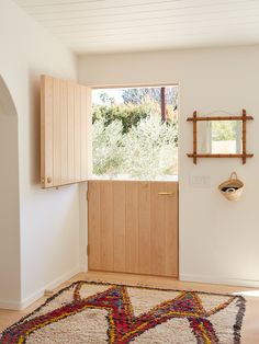 a room with a rug, mirror and wooden cabinet in the corner on the wall