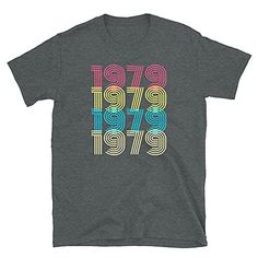 a gray t - shirt with the words 1989 written in multicolored letters on it