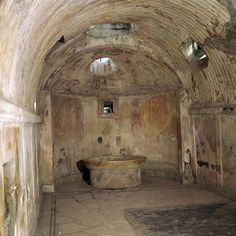 an old, run down room with a bathtub in the middle