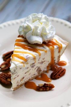 a piece of cheesecake on a white plate with pecans and caramel drizzle