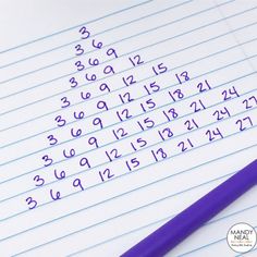 a purple pen sitting on top of a lined paper with numbers written in cursive writing