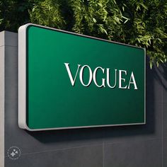 a green sign that says voquea on the side of a building with trees in the background